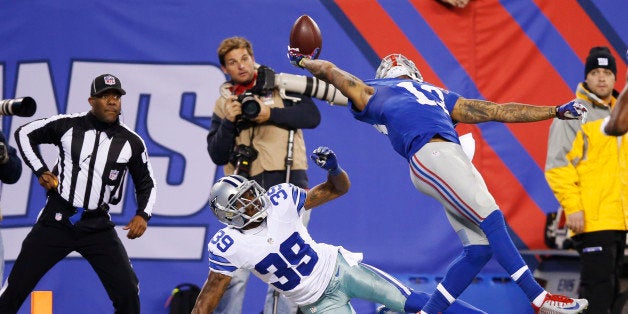 FILE - In this Nov. 23, 2014, file photo, New York Giants wide receiver Odell Beckham Jr. (13) makes a one-handed catch for a touchdown against Dallas Cowboys cornerback Brandon Carr (39) during an NFL football game in East Rutherford, N.J. Beckham's phenomenal three-fingered touchdown catch while falling backward into the end zone against Dallas can't be topped. "When I'm standing on the sidelines, I'm rooting for him all the way," coach Tom Coughlin said. "When I get to Monday, sometimes I run it back an extra time." (AP Photo/Kathy Willens, File)