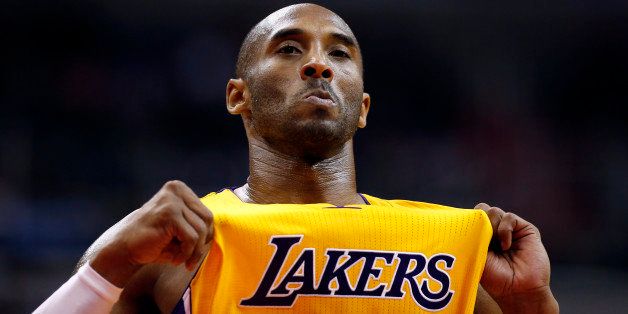 Los Angeles Lakers guard Kobe Bryant (24) holds out his jersey while on the court in the second half of an NBA basketball game against the Washington Wizards, Wednesday, Dec. 3, 2014, in Washington. The Wizards won 111-95. (AP Photo/Alex Brandon)