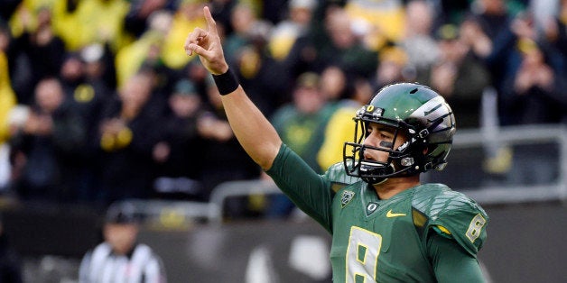 FILE - In this Nov. 22, 2014, file photo, Oregon quarterback Marcus Mariota (8) celebrates after scoring a touchdown during the first quarter of an NCAA college football game against the Colorado in Eugene, Ore. Mariota is The Associated Press college football player of the year. He won the AP vote in the same landslide fashion he won the Heisman Trophy, receiving 49 of the 54 votes submitted by the AP Top 25 media panel. (AP Photo/Steve Dykes, File0