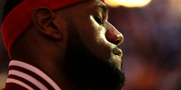 Cleveland Cavaliers' LeBron James stands during the playing of the national anthem before the first half of an NBA basketball game against the Orlando Magic, Friday, Dec. 26, 2014, in Orlando, Fla. (AP Photo/John Raoux)