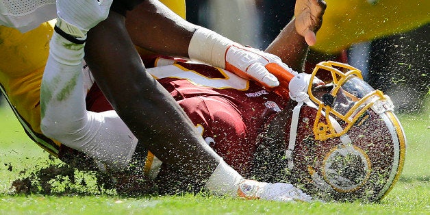 FILE - In this Sept. 23, 2012, file photo, Washington Redskins quarterback Robert Griffin III hits the turf after being sacked during the first half of an NFL football game against the Cincinnati Bengals in Landover, Md. NFL executives want to change the culture of the league _ and all of football _ to reduce head injuries. (AP Photo/Alex Brandon, File)