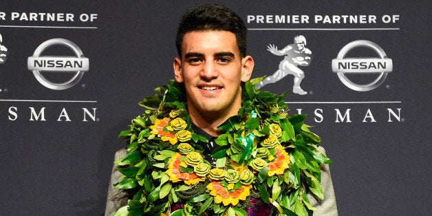 NEW YORK, NY - DECEMBER 13: Oregon Ducks quarterback Marcus Mariota poses with the Heisman Trophy during a press conference