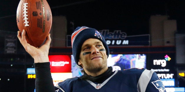 New England Patriots quarterback Tom Brady holds up the game ball after an NFL divisional playoff football game against the B