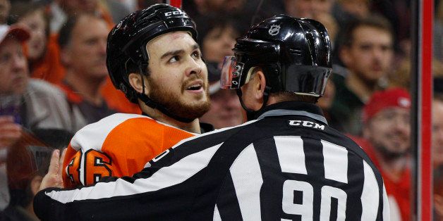 Philadelphia Flyers center Zac Rinaldo looks up as he is being held back by linesman Andy McElman and will be charged with a 10 minute game misconduct penalty during the third period of an NHL hockey game against the Vancouver Canucks, Thursday, Jan. 15, 2015, in Philadelphia. The Canucks won 4-0. (AP Photo/Chris Szagola)