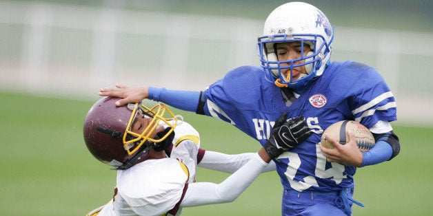 In this photo provided by Disney, Hunterdon Huskies' Derek Jenkins carries the ball as the West Grove Redskins' Joe Watson tries to make the tackle during the 2005 Pop Warner Division II Junior Pee Wees Championship at Disney's Wide World of Sports in Lake Buena Vista, Fla., Friday, Dec. 8, 2005. (AP Photo/Disney, Todd Anderson)