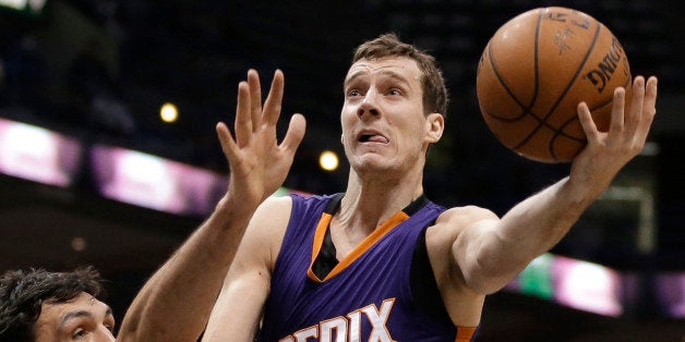 FILE - In this Jan. 6, 2015, file photo, Phoenix Suns' Goran Dragic attempts a layup over Milwaukee Bucks' Zaza Pachulia duri