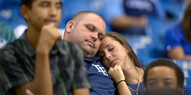 Two Tampa Bay Rays fans sleep in the stands during the 16th inning of a baseball game against the Baltimore Orioles in St. Pe