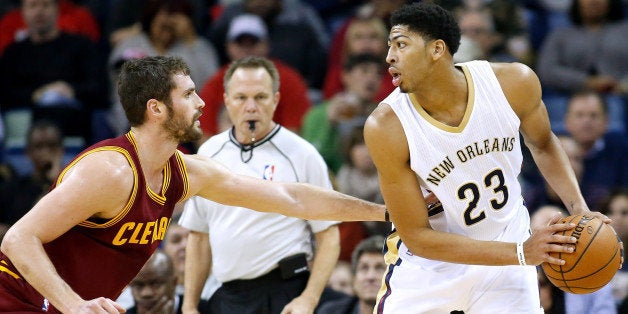 New Orleans Pelicans forward Anthony Davis (23) drives against Cleveland Cavaliers forward Kevin Love (0) during the first half of an NBA basketball game in New Orleans, Friday, Dec. 12, 2014. Davis left the game in the first quarter with an injury to the chest. (AP Photo/Jonathan Bachman)