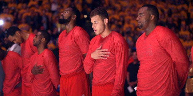 Los Angeles Clippers players listen to the national anthem wearing their warmup jerseys inside out to protest alleged racial remarks by team owner Donald Sterling before Game 4 of an opening-round NBA basketball playoff series against the Golden State Warriors on Sunday, April 27, 2014, in Oakland, Calif. (AP Photo/Marcio Jose Sanchez)