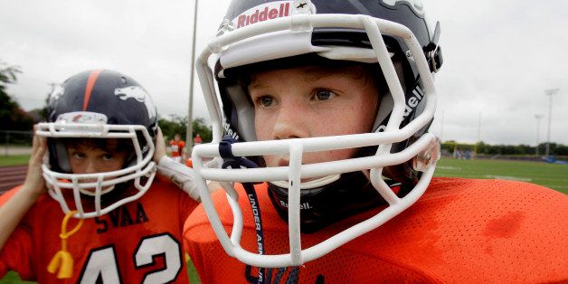In this photo made Saturday, Sept. 25, 2010, Reed Hoelscher, right, and teammate Alec Jordan (42) wait for the start of the second half of a 6th grade youth football game in Richardson, Texas. The boys play with a new type of football helmet designed to reduce the risk of concussions. (AP Photo/LM Otero)