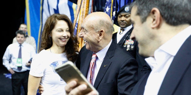 Actress Ashley Judd, left, and broadcaster Dick Vitale, talk before the first half of the NCAA college basketball Southeastern Conference tournament championship game between Kentucky and Arkansas, Sunday, March 15, 2015, in Nashville, Tenn. (AP Photo/Steve Helber)