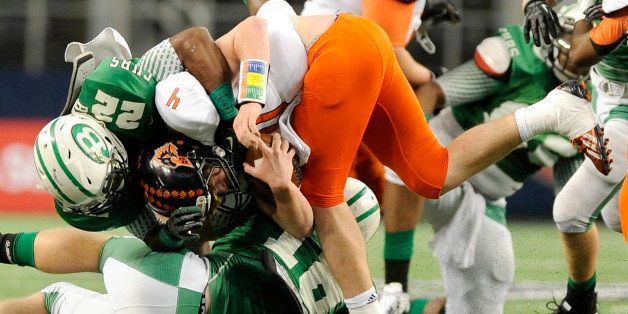 FILE - In this Dec. 21, 2013 file photo, Aledo quarterback Luke Bishop (4) is tackled by Brenham's Ryan Nunn (22) in the first half during the UIL Class 4A, Division II high school football championship game in Arlington, Texas. Nearly half of parents say theyâre not comfortable letting their child play football amid growing uncertainty about the long-term impact of concussions, according to an Associated Press-GfK poll. A majority, however, say they havenât prevented their child from playing the game they love. (AP Photo/Matt Strasen)