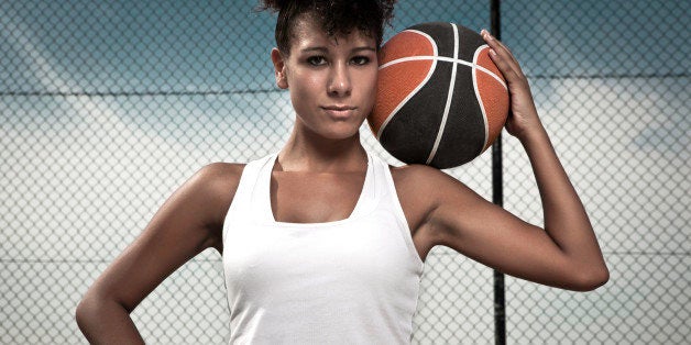 Portrait of female basketball player posing with basketball.