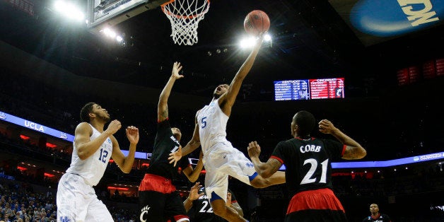 Kentucky's Andrew Harrison (5) drives in for the basket and a foul as the Wildcats defeated Cincinnati, 64-51, in the third r