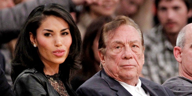 FILE - In this Dec. 19, 2011, file photo, Los Angeles Clippers owner Donald Sterling, right, sits with V. Stiviano as they wa
