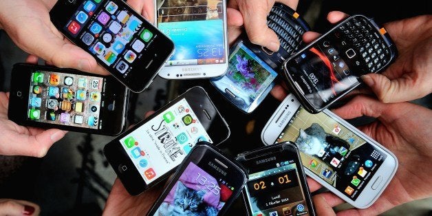 People show their smartphones on December 25, 2013 in Dinan, northwestern France. AFP PHOTO / PHILIPPE HUGUEN (Photo