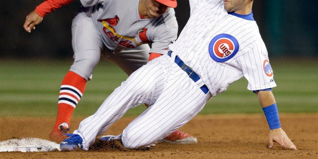 Chicago Cubs' Tommy La Stella, right, steals second base as St. Louis Cardinals second baseman Kolten Wong applies a late tag during the third inning of a Major League Baseball season-opening game in Chicago, Sunday, April 5, 2015. (AP Photo/Nam Y. Huh)