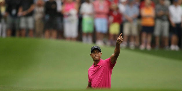 Tiger Woods points to his shot on the eighth fairway during a practice round for the Masters golf tournament Tuesday, April 7