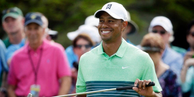 Tiger Woods smiles as waits to putt during a practice round for the Masters golf tournament Wednesday, April 8, 2015, in Augusta, Ga. (AP Photo/Darron Cummings)