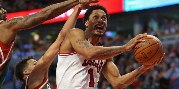CHICAGO, IL - APRIL 20: Derrick Rose #1 of the Chicago Bulls drives to the basket pagainst O.J. Mayo #00 and Michael Carter-