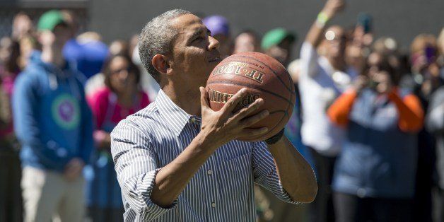 US President Barack Obama shoots a basketball during the annual White House Easter Egg Roll on the South Lawn of the White House in Washington, DC, April 21, 2014. The 126th annual White House Easter Egg Roll, the largest annual public event at the White House with more than 30,000 attendees expected, features live music, sports courts, cooking stations, storytelling and Easter egg rolling, with the theme, 'Hop into Healthy, Swing into Shape.' AFP PHOTO / Saul LOEB (Photo credit should read SAUL LOEB/AFP/Getty Images)