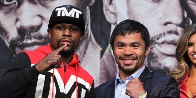 WBC/WBA welterweight champion Floyd Mayweather Jr. (L) and WBO welterweight champion Manny Pacquiao pose during a news conference at the KA Theatre at MGM Grand Hotel & Casino on April 29, 2015 in Las Vegas, Nevada. The two will face each other in a unification bout on May 2, 2015 in Las Vegas. AFP PHOTO / JOHN GURZINSKI (Photo credit should read JOHN GURZINSKI/AFP/Getty Images)