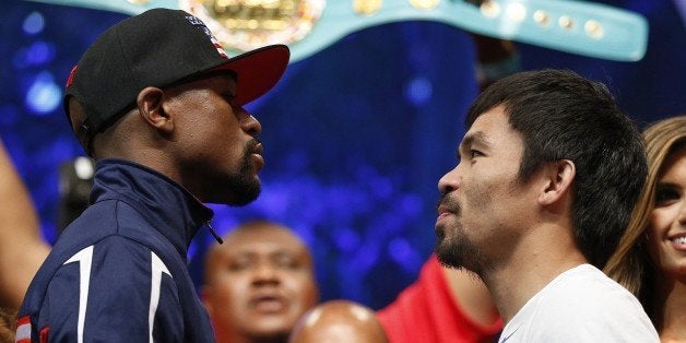 Floyd Mayweather Jr., left, and Manny Pacquiao pose during their weigh-in on Friday, May 1, 2015 in Las Vegas. The world weltherweight title fight between Mayweather Jr. and Pacquiao is scheduled for May 2. (AP Photo/John Locher)