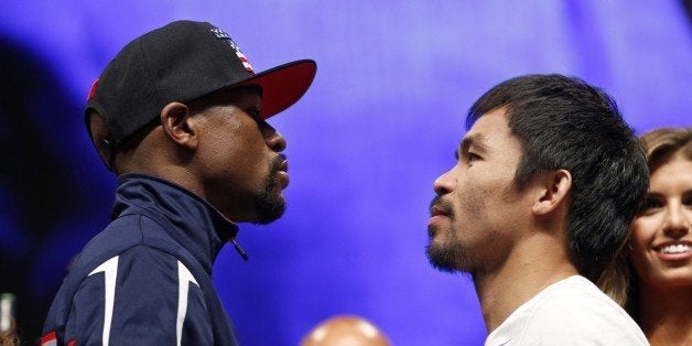 Floyd Mayweather Jr., left, and Manny Pacquiao pose during their weigh-in on Friday, May 1, 2015 in Las Vegas. The world weltherweight title fight between Mayweather Jr. and Pacquiao is scheduled for May 2. (AP Photo/John Locher)