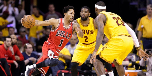 Chicago Bulls guard Derrick Rose (1) drives against Cleveland Cavaliers forward LeBron James (23) and guard Kyrie Irving (2) during the first half of Game 2 in a second-round NBA basketball playoff series Wednesday, May 6, 2015, in Cleveland. (AP Photo/Tony Dejak)