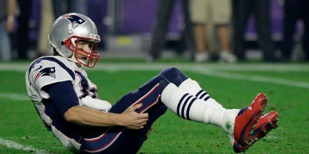 New England Patriots quarterback Tom Brady (12) sits on the turf after being hit during the second half of NFL Super Bowl XLIX football game against the Seattle Seahawks Sunday, Feb. 1, 2015, in Glendale, Ariz. (AP Photo/David Goldman)