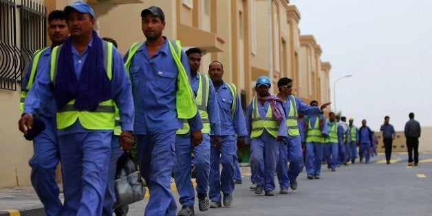 Foreign laborers working on the construction site of the al-Wakrah football stadium, one of the Qatar's 2022 World Cup stadiums, walk back to their accomodation at the Ezdan 40 compound after finishing work on May 4, 2015, in Doha's Al-Wakrah southern suburbs. The Qatari government has announced new projects to provide better accommodation for up to one million migrant workers. Today they organised a media tour of existing housing camps and new ones. AFP PHOTO / MARWAN NAAMANI (Photo credit should read MARWAN NAAMANI/AFP/Getty Images)