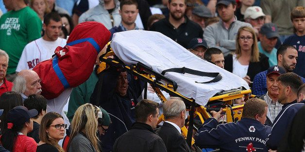 BOSTON, MA - JUNE 5: A fan is attended to by medical staff after she was hit by a broken bat during a game between the Boston Red Sox and the Oakland Athletics in the second inning at Fenway Park on June 5, 2015 in Boston, Massachusetts. (Photo by Jim Rogash/Getty Images)