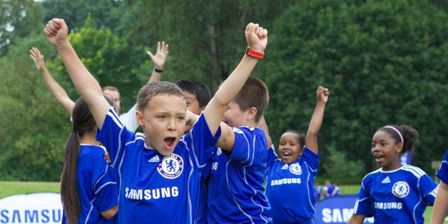 COMMERCIAL IMAGE - Campers from Seattle-area Boys and Girls Clubs celebrate a goal during he Samsung-Chelsea FC Youth Football Camp at Starfire Sports Complex on Tuesday July 17, 2012 near Seattle. (Photo by Stephen Brashear/Invision for Samsung Electronics America/AP Images)