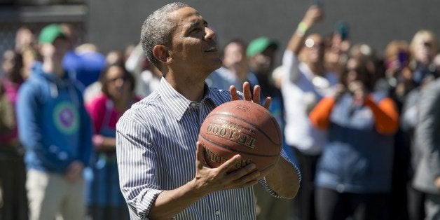 US President Barack Obama shoots a basketball during the annual White House Easter Egg Roll on the South Lawn of the White House in Washington, DC, April 21, 2014. The 126th annual White House Easter Egg Roll, the largest annual public event at the White House with more than 30,000 attendees expected, features live music, sports courts, cooking stations, storytelling and Easter egg rolling, with the theme, 'Hop into Healthy, Swing into Shape.' AFP PHOTO / Saul LOEB (Photo credit should read SAUL LOEB/AFP/Getty Images)