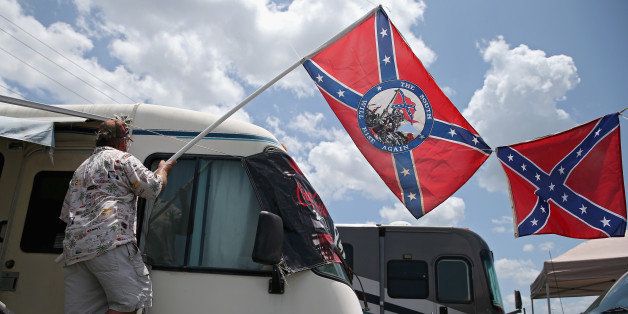 DAYTONA BEACH, FL - JULY 03: A fan holds a Confederate flag during practice for the NASCAR XFINITY Series Subway Firecracker 250 at Daytona International Speedway on July 3, 2015 in Daytona Beach, Florida. (Photo by Patrick Smith/Getty Images)