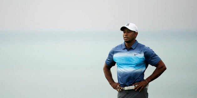 Tiger Woods pauses after hitting a shot on the 11th hole during the first round of the PGA Championship golf tournament Thurs