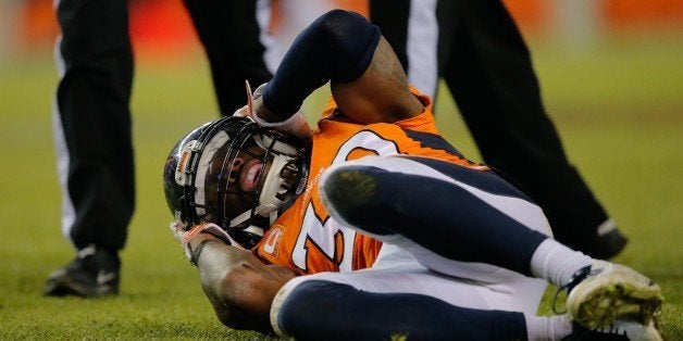 DENVER, CO - DECEMBER 28: Strong safety David Bruton #30 of the Denver Broncos lies on the ground in pain after a play that would force him out of the game with a reported concussion during a game against the Oakland Raiders at Sports Authority Field at Mile High on December 28, 2014 in Denver, Colorado. (Photo by Doug Pensinger/Getty Images)