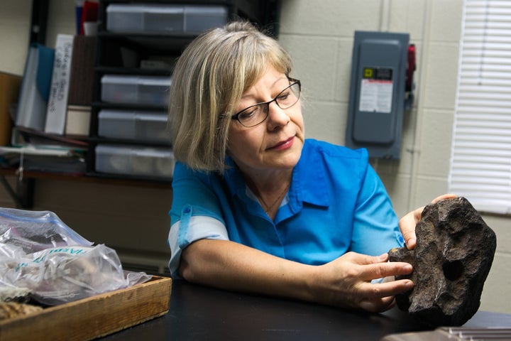 CMU geology faculty member Mona Sirbescu holds the 22.5 pound meteorite used as a doorstop for decades.