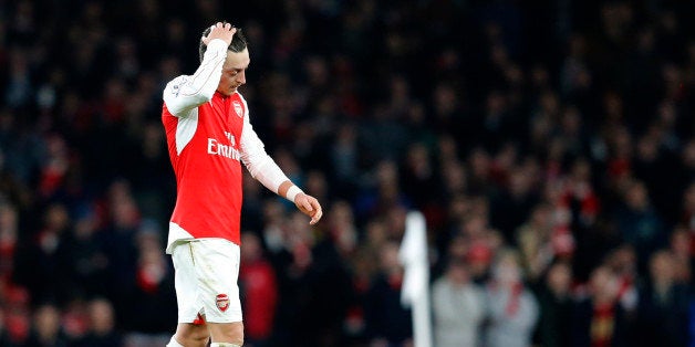 Arsenal's Mesut Ozil puts his hand to his head as he waits for a free kick to be taken during the English Premier League soccer match between Arsenal and Chelsea at the Emirates stadium in London, Sunday, Jan. 24, 2016.(AP Photo/Frank Augstein)