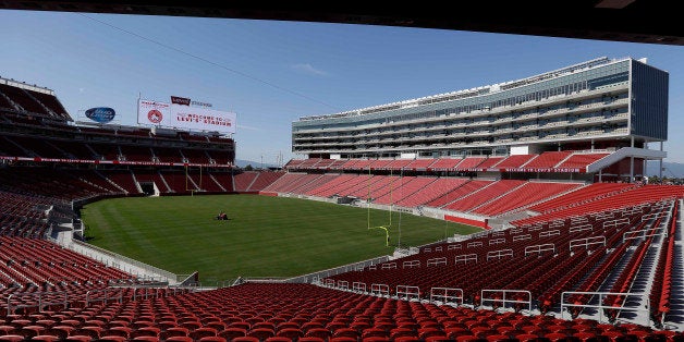 FILE - In this July 17, 2014, file photo, a groundskeeper drives across the field before the ribbon-cutting and opening of Levi's Stadium in Santa Clara, Calif. When the architects set out to design a new football stadium for the San Francisco 49ers, they wanted a building that fit the Silicon Valley region where it is located. Retro was out. High-tech and green-friendly were in. (AP Photo/Eric Risberg, file)