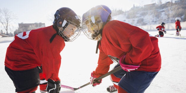 Hockey players facing off on ice rink