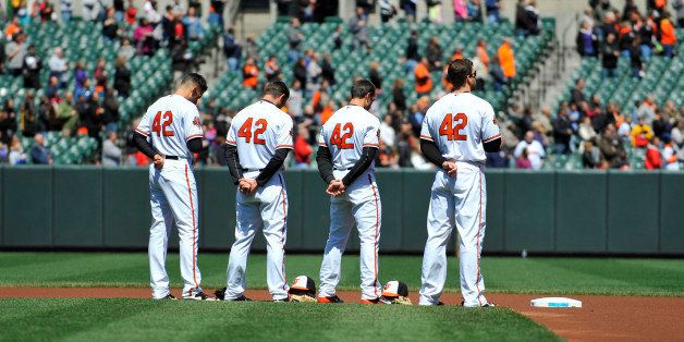 Apr 16, 2014; Baltimore, MD, USA; Baltimore Orioles infielders Ryan Flaherty (left) J.J. Hardy (center left) Steve Lombardozzi (center right) and Chris Davis (right) honor Jackie Robinson during the national anthem prior to a game against the Tampa Bay Rays at Oriole Park at Camden Yards. Mandatory Credit: Joy R. Absalon-USA TODAY Sports