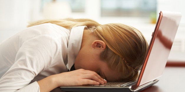 Image of very tired businesswoman or student with her face on keyboard of laptop Note to inspector: the image is pre-Sept 1