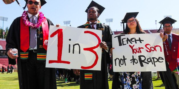 Stanford students John Lancaster Finley(L) and Brandon Hill(C) carry signs during the 'Wacky Walk' to show their solidarity for a Stanford rape victim during graduation ceremonies at Stanford University, in Palo Alto, California, on June 12, 2016. / AFP / GABRIELLE LURIE (Photo credit should read GABRIELLE LURIE/AFP/Getty Images)