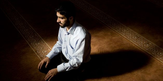 Young muslim man praying in mosque