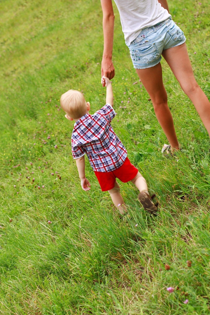 small child holding hand with...