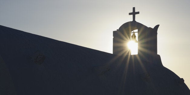 Greece, Sun shines through belltower in Oia village at Santorini