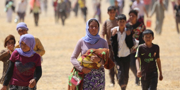 MOSUL, IRAQ - AUGUST 9: Thousands of Yezidis trapped in the Sinjar mountains as they tried to escape from Islamic State (IS) forces, are rescued by Kurdish peshmerga forces and Peoples Protection Unit (YPG) in Mosul, Iraq on August 09, 2014. (Photo by Emrah Yorulmaz/Anadolu Agency/Getty Images)