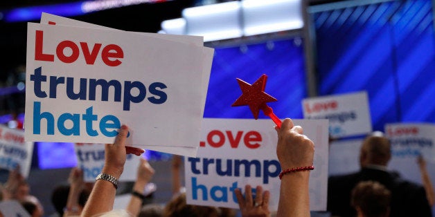 Delegates wave "Love trumps hate" signs towards the podium during the first session at the Democratic National Convention in Philadelphia, Pennsylvania, U.S. July 25, 2016. REUTERS/Mark Kauzlarich