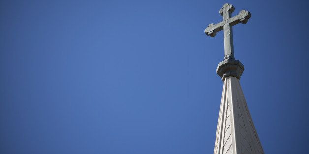 A Crucifix rises high above the skyline on top of a church's steeple.
